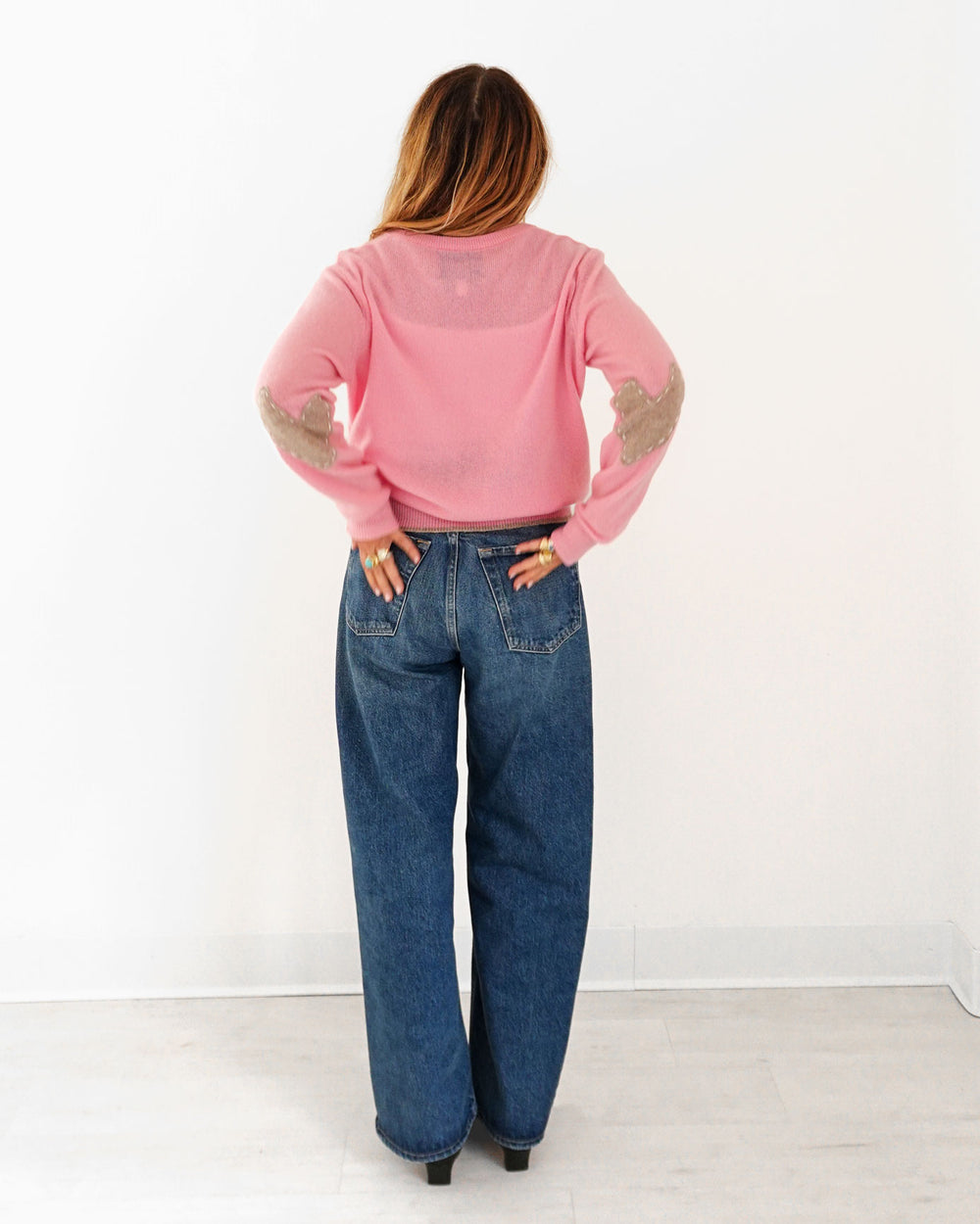 Kerri wearing the Patchwork Pullover Sweater in pink with jeans, back view
