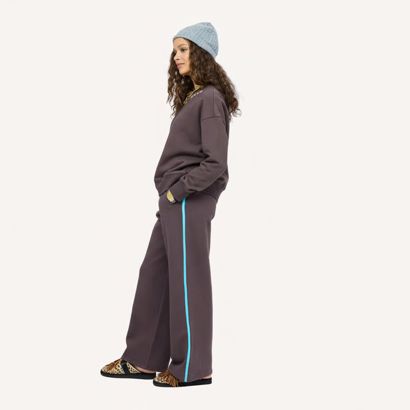 Model wearing  Weekend Palazzo Sweatpant wide-leg trouser with a sporty stripe down the leg, side view.