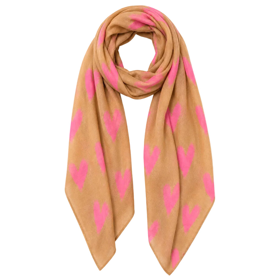 A tan scarf with a repeating bright pink heart pattern, arranged in a loop on a plain white background.