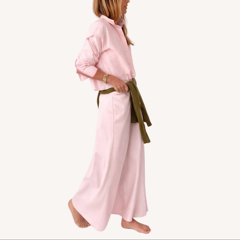 Side view of a pink striped shirt with 'LOVE' lettering and heart elbow patches and pink maxi skirt and army green sweater wrapped around waist.