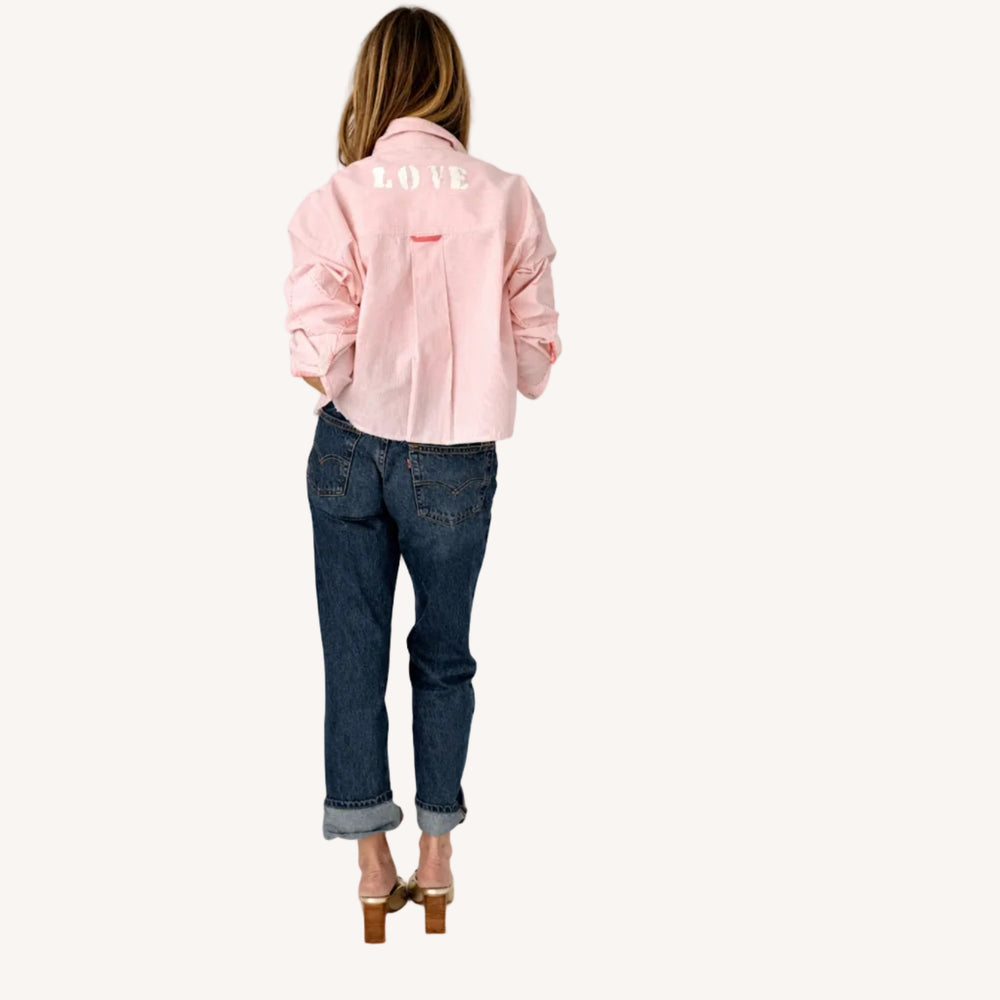 Back view of a pink striped shirt with 'LOVE' lettering and heart elbow patches.