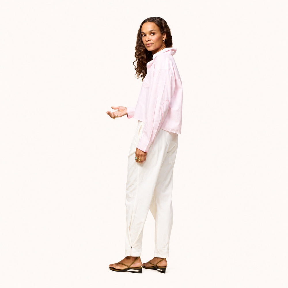 Side view of a pink striped shirt with 'LOVE' lettering and heart elbow patches and cream pants by Kerri Rosenthal