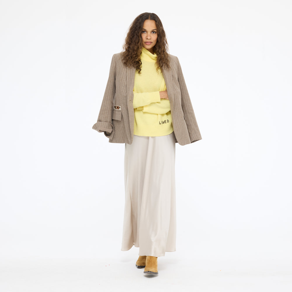 Model wearing the Mad Love Mock Neck Sweater in golden yellow with the Workday Love Brigade Blazer in taupe over her shoulders and the Ali Maxi Skirt in taupe, front view