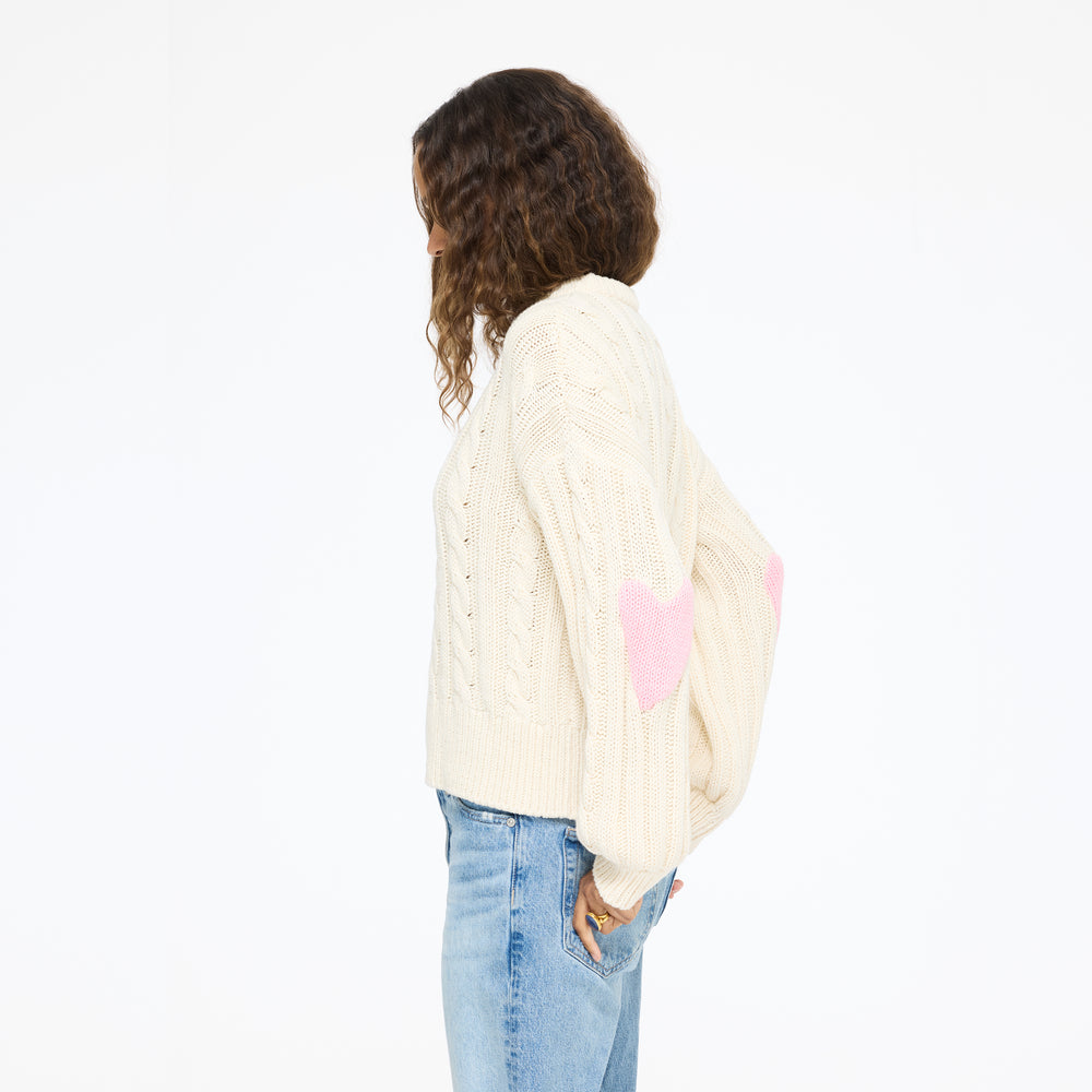 Model wearing the Rocky Patchwork Sweater in cream with jeans, side view