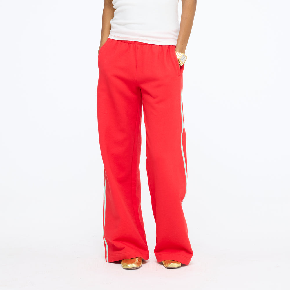 Waist-down front view of the Super Soft Fleece Weekend Palazzo in red with a white side stripe, with a white tee