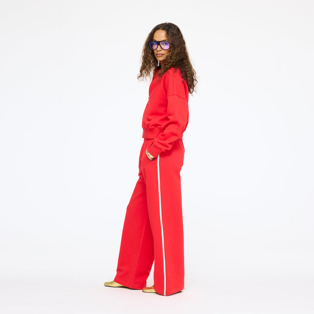 Model wearing the Super Soft Fleece Weekend Palazzo in red with the Sunday Quarter Zip Sweatshirt in red, full length side view