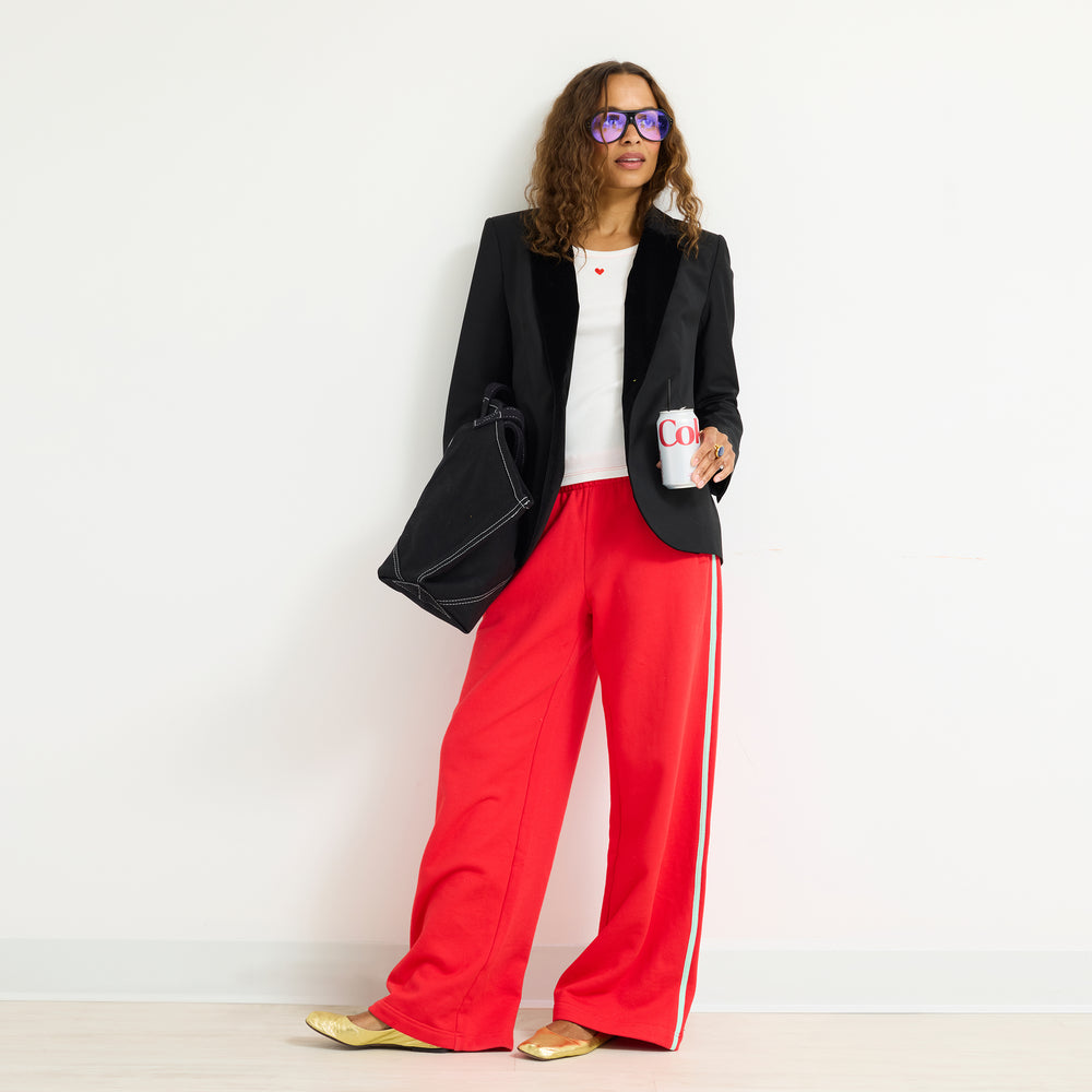 Model wearing the Super Soft Fleece Weekend Palazzo in red with a black blazer, hand in her pocket, full length front view