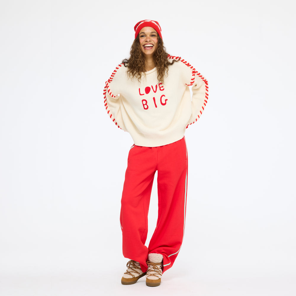 Model wearing the Super Soft Fleece Weekend Palazzo in red with the Love Big Sweater in cream and the Rosey Beanie, front view