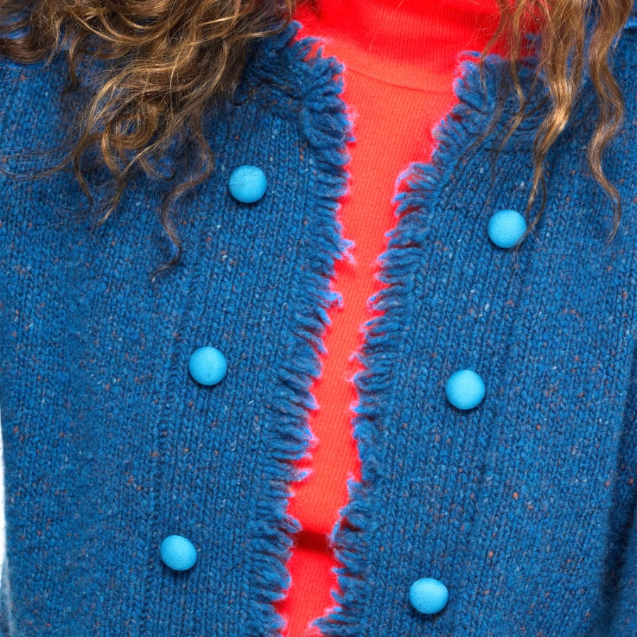 Close-up of the Fringe Beau-Lero in electric blue showing round blue buttons and red trim over a red top