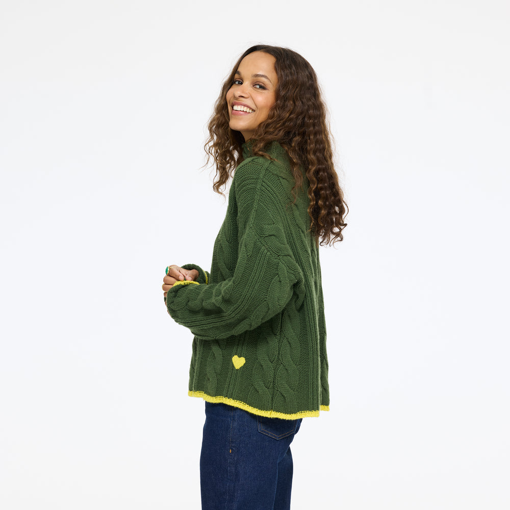 Model wearing the Hearth Sweater in spruce with jeans, side view
