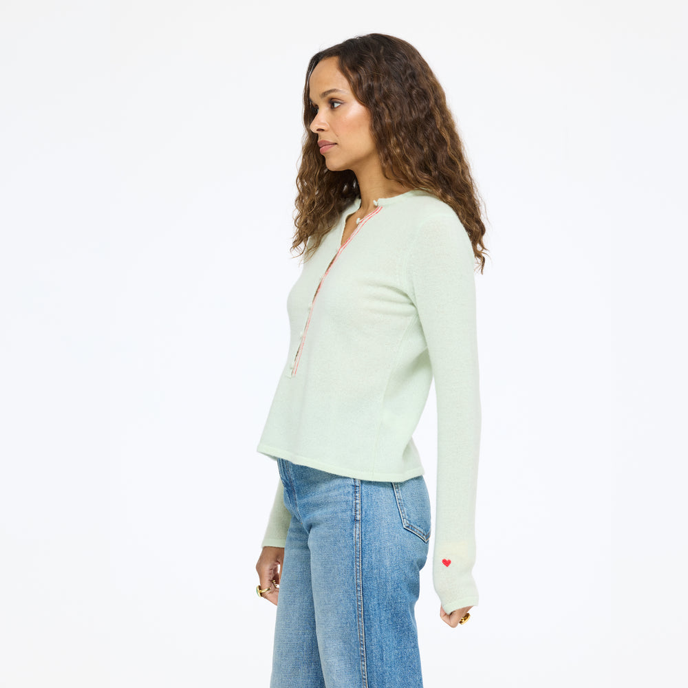 Model wearing the Pixie Sweater in pistachio with jeans, three-quarter side view