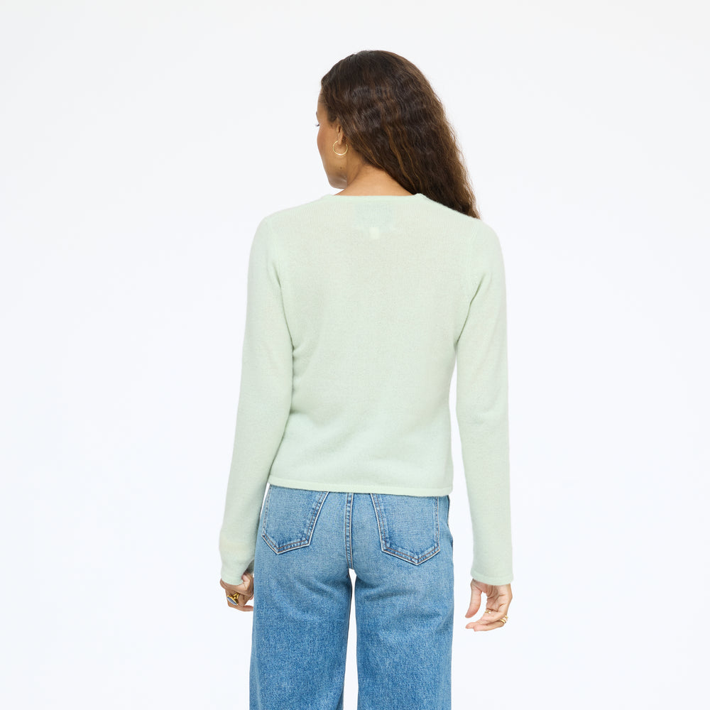 Model wearing the Pixie Sweater in pistachio with jeans, back view