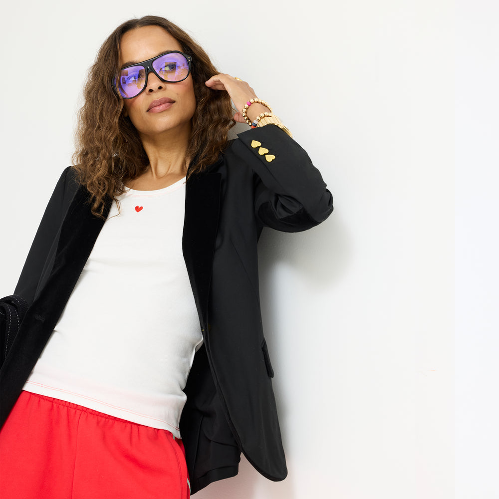 Model wearing the KR Tank in white under a black blazer with the Super Soft Fleece Weekend Palazzo in red