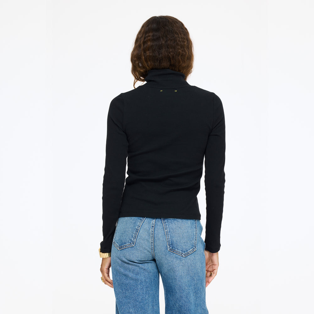 Model wearing the Mock Neck Rib Tee in black with jeans, back view