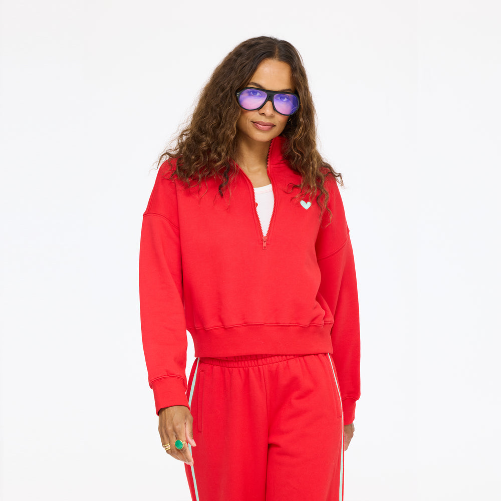 Model wearing the Sunday Quarter Zip Sweatshirt in red with the Super Soft Fleece Weekend Palazzo in red and sunglasses, front view