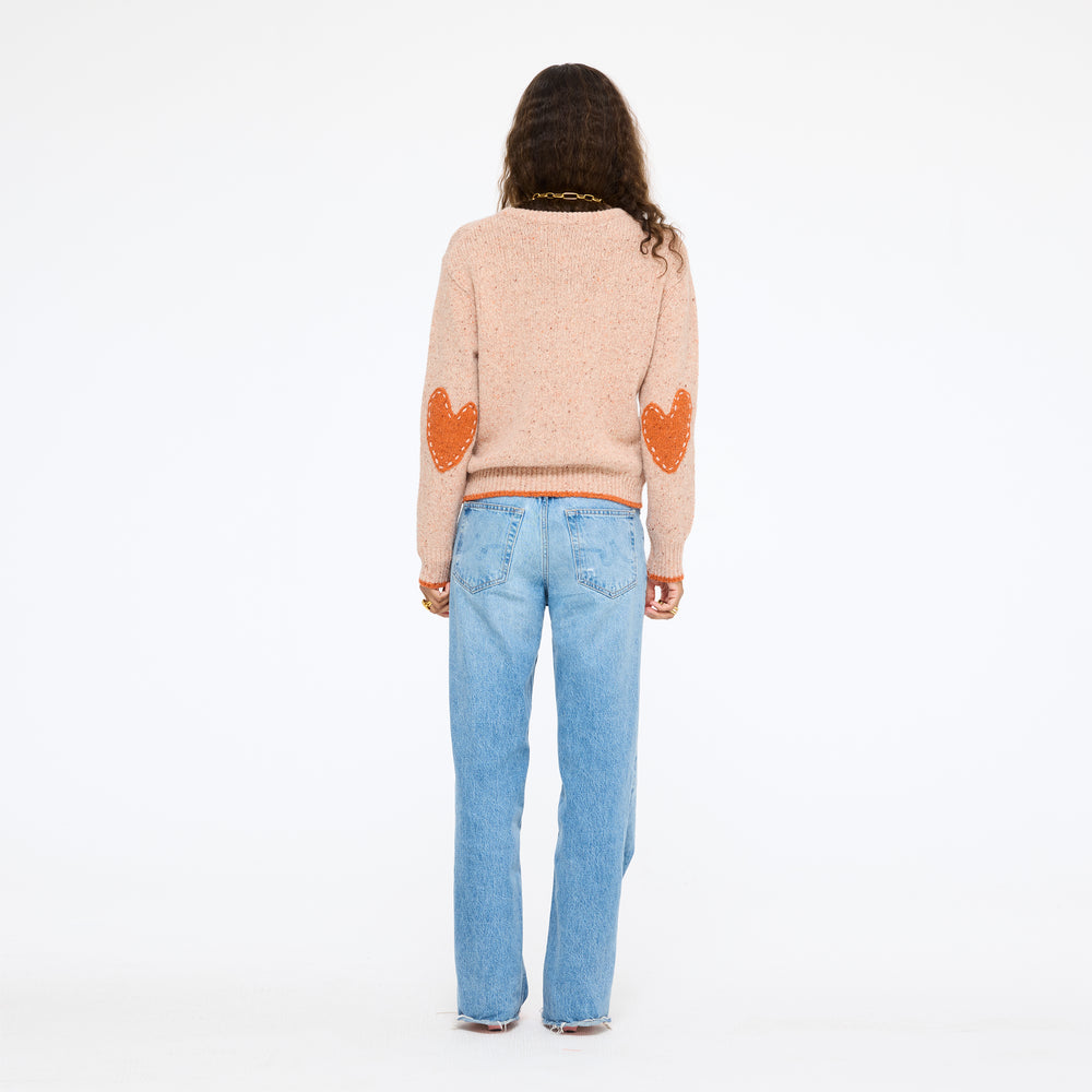 Model wearing the Patchwork Pullover Sweater in blush with jeans, full length view