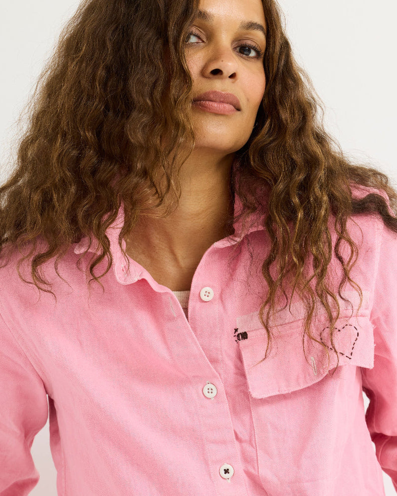 Close-up portrait of the model wearing the Pia Fireside and Kisses Shirt in pink