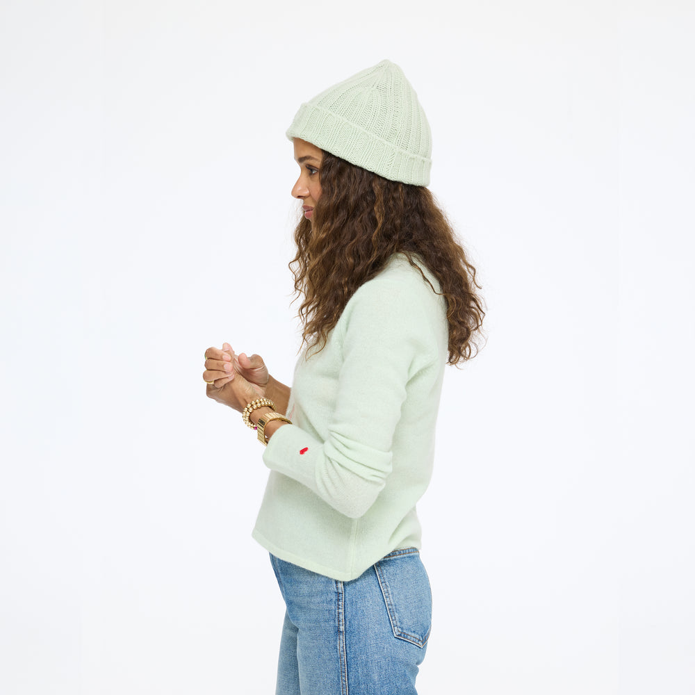 Model wearing the Winter Beanie in pistachio with the Pixie Sweater in pistachio and jeans, side view