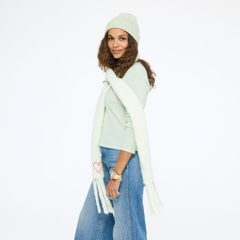 Model wearing the Winter Beanie in pistachio with the Pixie Sweater, the Cloud Hopping Scarf in pistachio, and jeans, three-quarter view