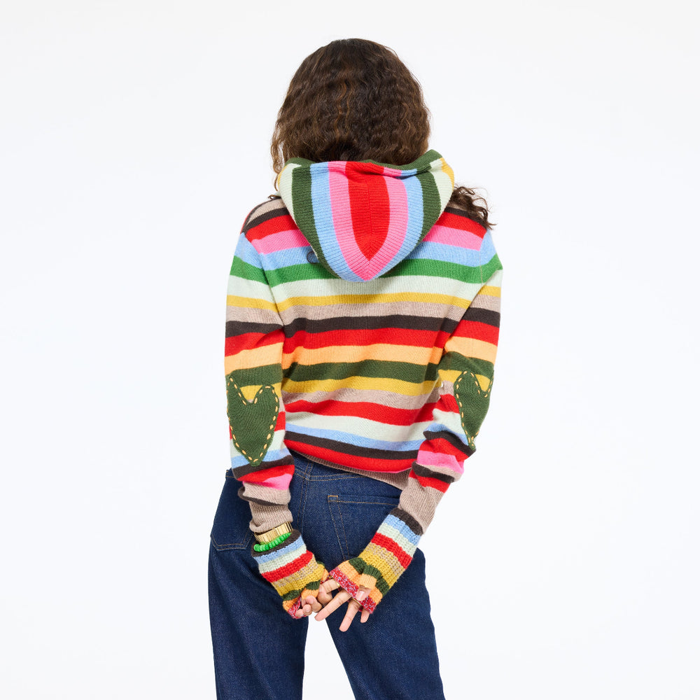 Model wearing the McLuvin Hoodie in multicolor stripe over the Patchwork Pullover Stripe Sweater with jeans, hands clasped behind her, back view