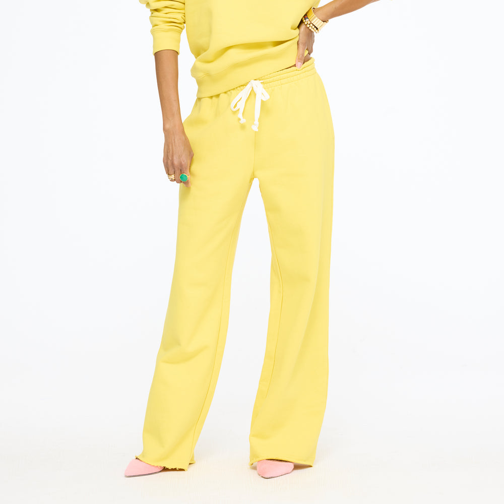 Waist-down view of the Weekend Barb Sweatpant in washed sunshine yellow with a drawstring waist and a yellow sweatshirt, hand on hip