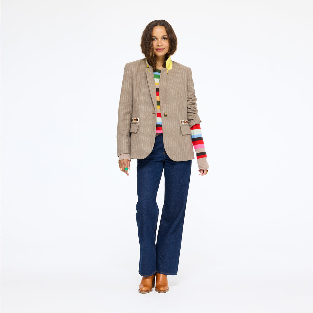 Model wearing the Workday Love Brigade Blazer in taupe pinstripe with multicolor striped sleeves underneath, navy trousers, and tan shoes, full length front view