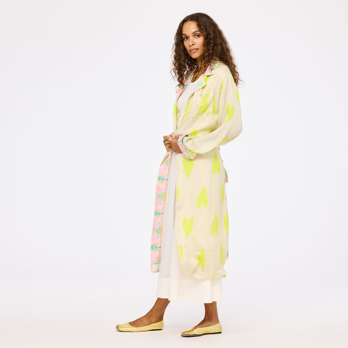 Kerri Rosenthal women's cream and neon lime green heart print maxi duster coat with pink floral contrast trim, layered over a white maxi skirt.