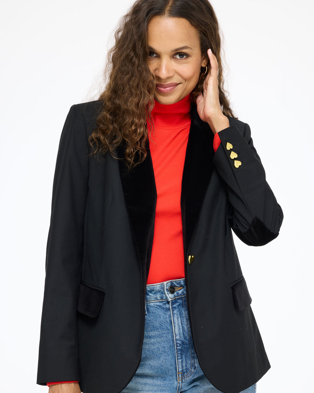 Model wearing the Mock Neck Rib Tee in red under the Workday Fancy Blazer in black, hand at her collar