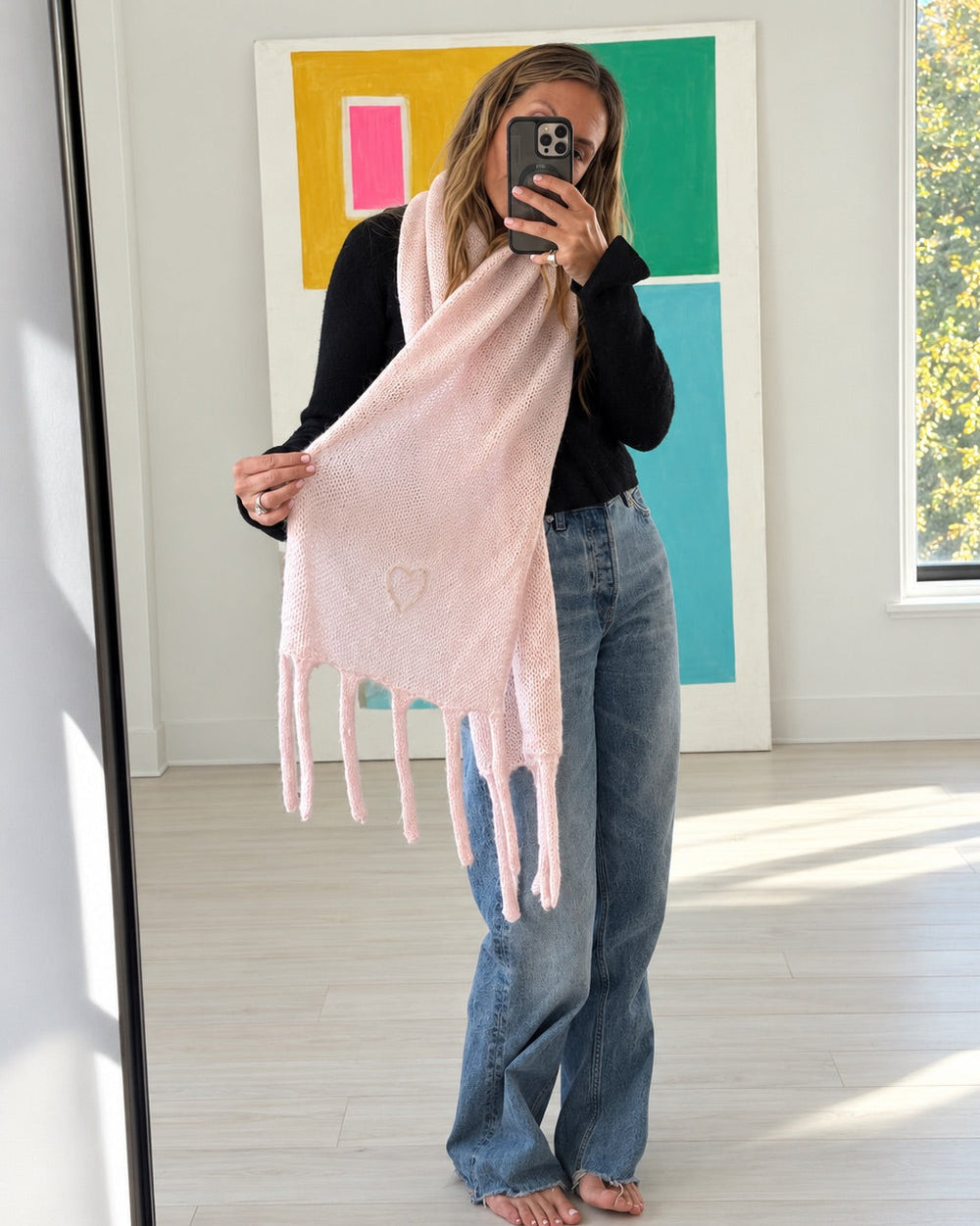 Kerri wearing the Cloud Hopping Scarf in hardly pink draped around her neck with a black top and jeans