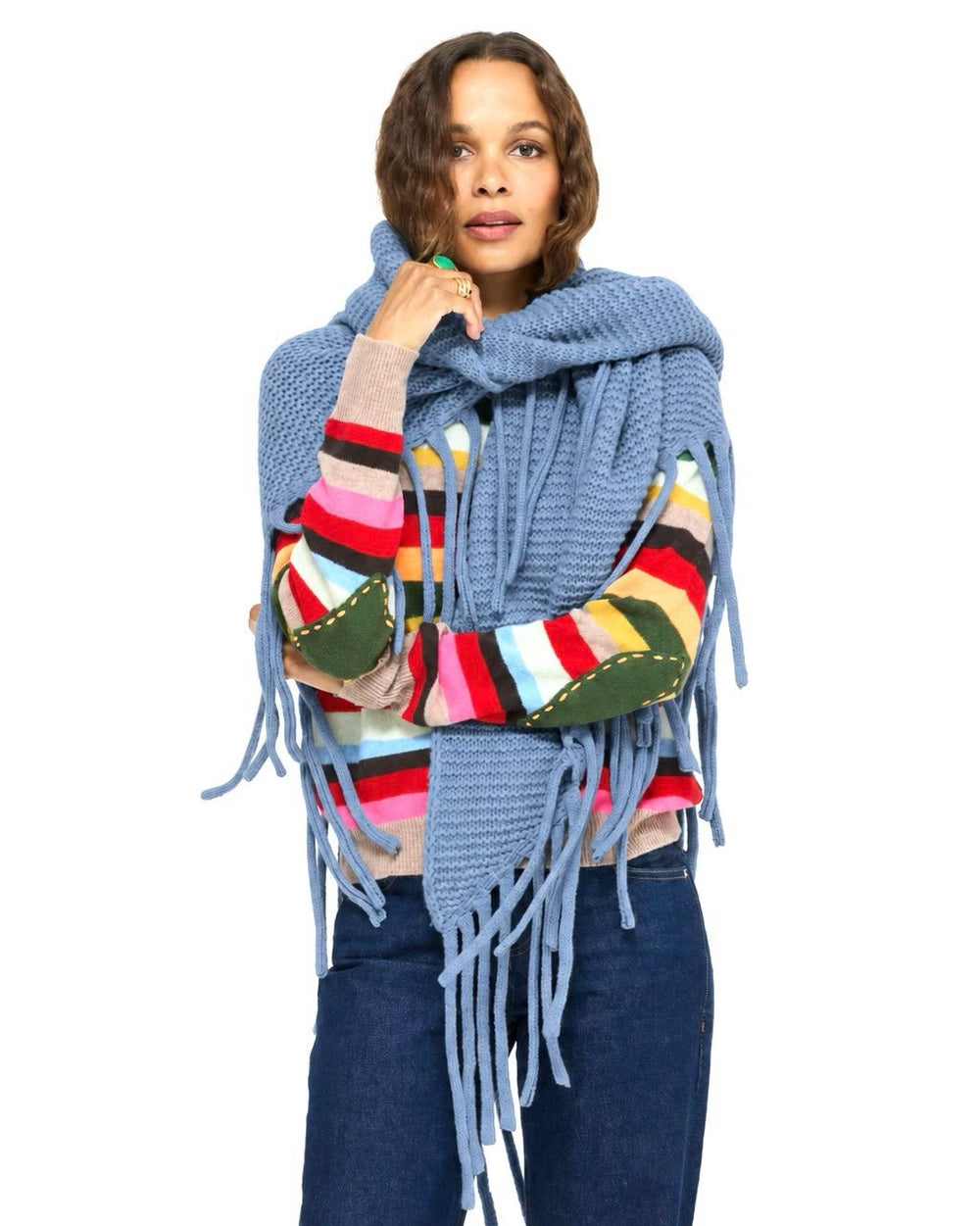 Model wearing the Love Nest Wrap in blue around her shoulders over the Patchwork Pullover Stripe Sweater and jeans, front view