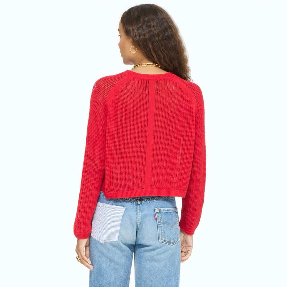 Person wearing a red sweater and blue denim shorts on a white background