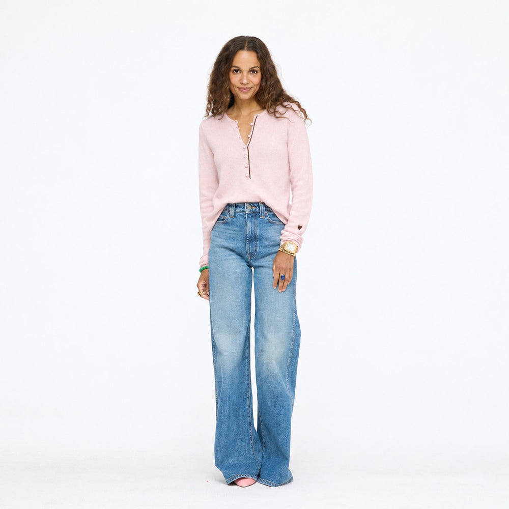 Model wearing the Pixie Sweater in pink with wide-leg jeans, full length front view