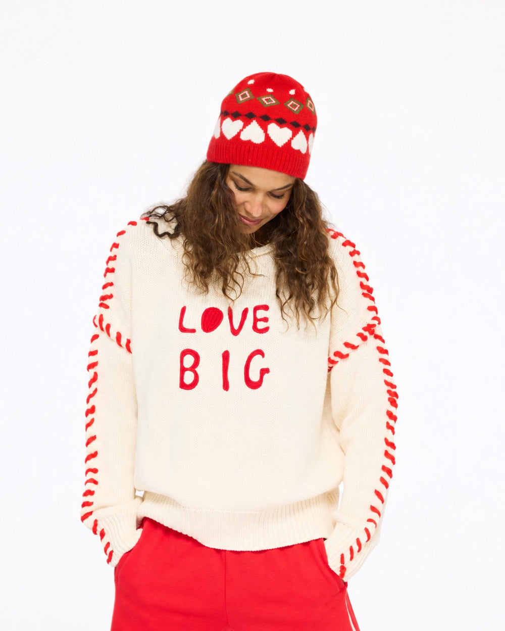 Model wearing the Rosey Beanie in red with the Love Big Sweater in cream and the Super Soft Fleece Weekend Palazzo in red, front view