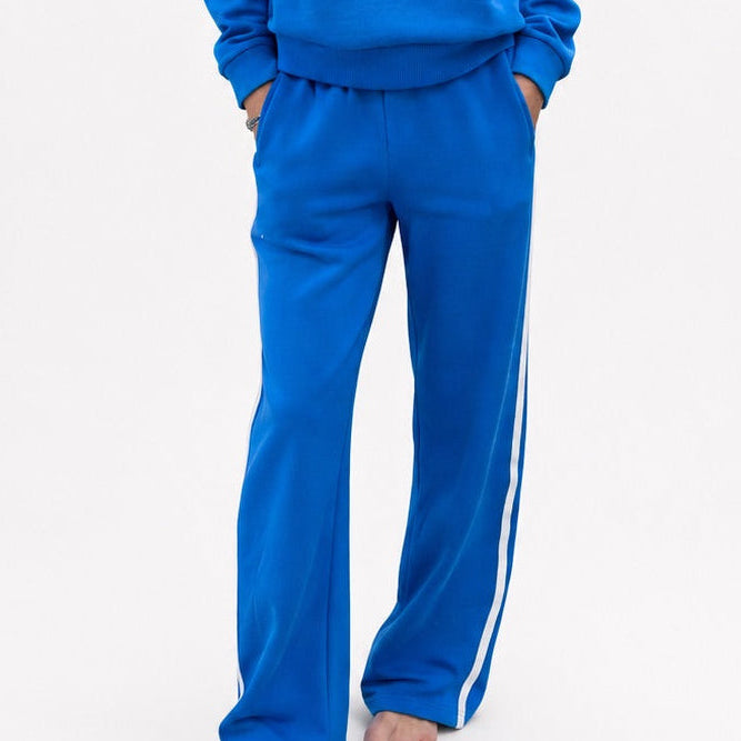 Close-up of blue track pants with white side stripe and matching sweatshirt.