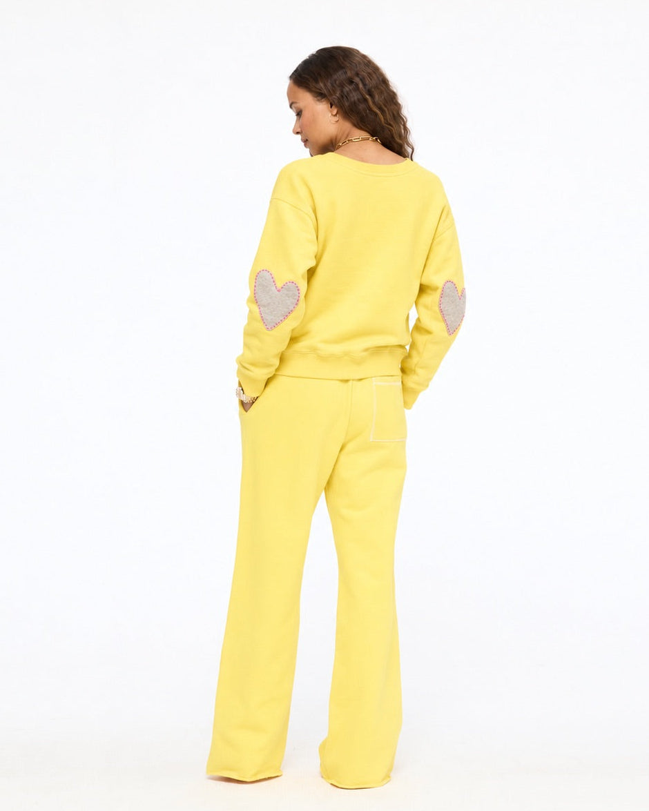 Model wearing the Weekend Barb Sweatpant with the Boyfriend Imperfect Heart Sweatshirt in washed sunshine yellow, back view