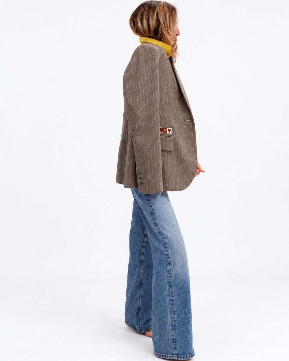 Kerri wearing the Workday Love Brigade Blazer in taupe pinstripe with jeans, side view